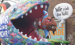 A carnival float featuring a ''We Are More'' shark that is eating a smaller shark with an...