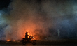 A motorcyclist is riding past burning garbage on a busy road in Dhaka, Bangladesh, on Febr...
