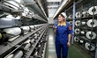 A worker is inspecting production at a workshop of a chemical fiber company in Suqian, Eas...
