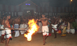 Tamil Hindu devotees are performing a votive dance while twirling fire as they celebrate t...
