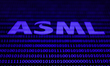 A binary code displayed on a laptop screen and ASML logo displayed on a phone screen are s...
