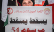 A female demonstrator is holding a placard that reads in Arabic, ''Down with decree 54,''...