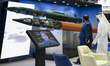 Visitors are looking at the Lockheed Martin company stand at the Doha International Mariti...