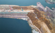 Construction workers and large machinery are working on the Heilongtan Reservoir reinforce...