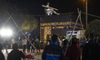 An Iranian street artist is performing in front of a scale model of the Kaaba in a park in...