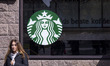 A store of Starbucks Coffee shop chain located in Amsterdam city center with people sittin...