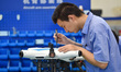 Workers are assembling civilian multi-rotor drones at a production workshop of a drone fac...