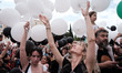 People are holding balloons during a demonstration marking International Labour Day in Ath...
