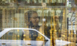 A young Iranian woman is taking photographs while standing at a gold shop in a bazaar in B...