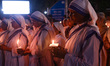 Indian Christian nuns are holding candles as they pray during a candlelight vigil outside...