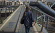 An Iranian woman is walking along a pedestrian bridge and looking on in eastern Tehran, Ir...