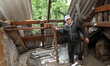 A displaced man from Avdiivka, Donetsk region, is being pictured in a house damaged by the...