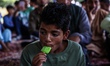 Kashmiri Muslim boys are eating ice cream as they are taking part in a religious program o...