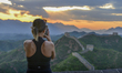 A tourist is taking photos of fish scale clouds at sunset over the Jinshanling section of...
