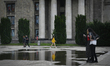 A woman in a yellow sweater is seen walking past a puddle near the Palace of Culture and S...