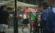 A waitress carrying coffee and rinks is seen during a sudden downpour in Warsaw, Poland on...