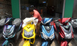 A person is displaying electric scooters for sale outside a showroom on the outskirts of K...