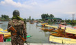 An Indian security personnel is standing guard on the banks of Dal Lake before the arrival...