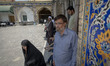 Iranian people are standing in line at a polling station at a holy shrine in the Shahr-e-R...