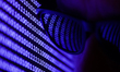 A binary code displayed on a laptop screen and reflected in sunglasses are seen in this il...