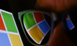 Microsoft logo displayed on a phone screen and reflected on sunglasses is seen in this ill...