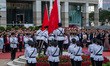A police officer is raising the National Flag of China and the HKSAR flag at Bohemia Squar...