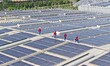 Power technicians are inspecting the operation of rooftop solar photovoltaic modules in Ch...