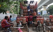 Workers are waiting to unload Liquefied Petroleum Gas (LPG) cylinders to load onto their c...