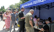 Police officers are helping people near a shopping mall damaged by the Russian missile str...