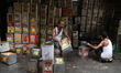 Workers are cleaning empty cooking oil containers at a roadside recycling workshop in Kolk...