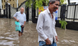 People are walking on a waterlogged street after heavy rains in Kolkata, India, on August...