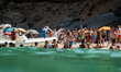 Tourists are embarking and disembarking from a touristic boat at Cala Biriala in the Oglia...
