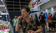 A woman is trying a food sample at the Hong Kong Food Expo in Hong Kong, China, on August...