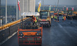 Workers spread asphalt on the deck of the main bridge of the Longtan Yangtze River Bridge...