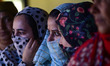 Women voters queue to cast their ballots at a polling station during the first phase of as...