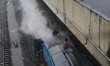 Boys ride on a train rooftop during rainfall in Dhaka, Bangladesh, on September 26, 2024. 