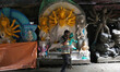 An artisan speaks on his mobile phone after preparing idols of the Hindu goddess Durga at...