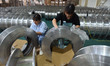 A worker cleans a tray at Pacific Special Mesh Industry Co., LTD in Fuyang, China, on Sept...