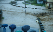 Residents of Kathmandu stand on the embankment of a flooded river in Kathmandu, Nepal, on...