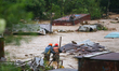 Nepal's Armed Police Force personnel attempt to reach a stranded person from a flooded riv...