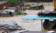 Nepal's Armed Police Force personnel rescue a stranded person from a flooded river in Lali...