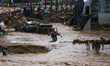 Nepal's Armed Police Force personnel wade through a flooded river to rescue stranded peopl...