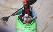 A Nepal Army personnel evacuates an infant using a kayak from a flooded residential area i...