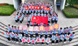 Primary school students pose for a photo with the national flag to celebrate the 75th anni...