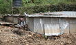 A Nepali man rests next to a tin shelter damaged by a landslide in Dhading district of Cen...