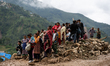 Spectators and relatives watch as the rescue teams conduct search operations at Jhyaple Kh...