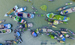 An aerial view shows traders selling fruits and vegetables from boats at Boithakata floati...