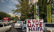 An elderly Iranian protester holds an anti-Israeli placard while taking part in a protest...