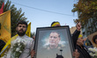 An Iranian protester carries a portrait of Islamic Revolutionary Guard Corps' (IRGC) Quds...