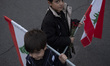 Two Iranian schoolboys hold Lebanese flags while taking part in a protest gathering with t...